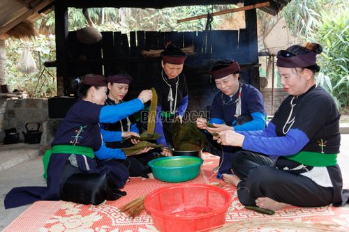 Người phụ nữ Tày Khao khéo léo xếp lá, cho gạo vào khuôn lá và gói bánh bằng đôi bàn tay thuần thục.