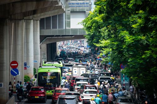 Nhiều ôtô của phụ huynh dừng đỗ dọc cổng trường để đợi con, khiến mặt đường bị thu hẹp. Dòng xe máy, ôtô nối dài, di chuyển chậm qua khu vực cổng trường. Một số thời điểm, các phương tiện gần như nhích từng chút một.