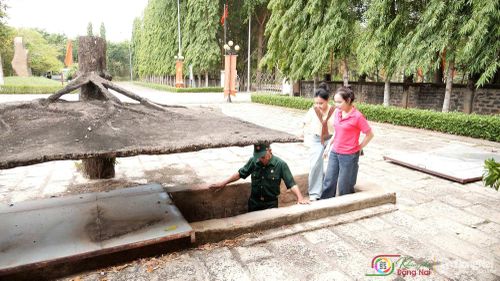Cựu chiến binh Lê Thanh Hải giới thiệu hệ thống địa đạo tại Di tích lịch sử cấp quốc gia Địa đạo Nhơn Trạch cho 2 MC và khán giả của "Khám phá Đồng Nai". Ảnh: Tiến Dũng