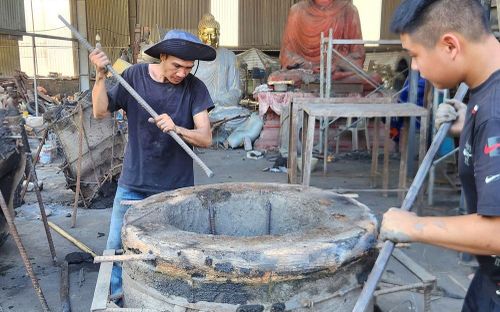 Công đoạn phá khuôn được thực hiện cẩn trọng để lộ dần hình hài chiếc trống đồng sau nhiều giờ đúc thủ công