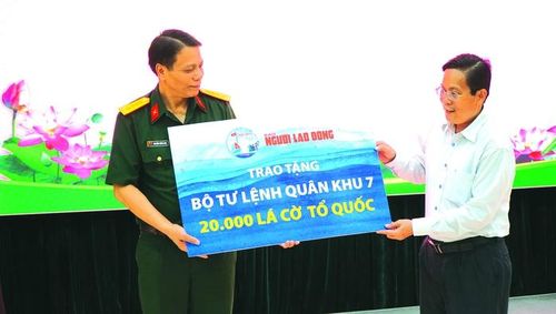 Tổng Biên tập Báo Người Lao Động Tô Đình Tuân trao bảng tượng trưng 20.000 lá cờ Tổ quốc cho Đại tá Nguyễn Công Anh - Phó Chủ nhiệm Chính trị Bộ Tư lệnh Quân khu 7, ngày 23-5-2022. Ảnh: THANH LONG