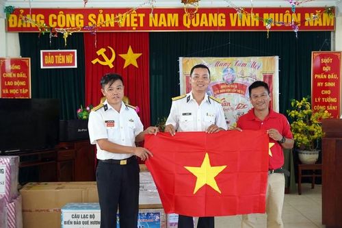 Đại diện Báo Người Lao Động, tác giả Quang Liêm trao cờ Tổ quốc tới cán bộ, chiến sĩ đảo Tiên Nữ. Ảnh: NGỌC LINH