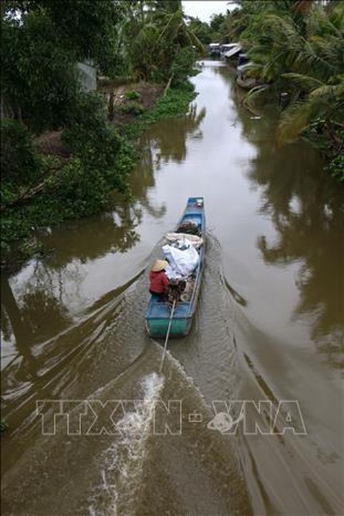 Do đường giao thông nhỏ hẹp, cầu giao thông dốc cao nên có ý kiến cho rằng dùng ghe thuyền thu gom rác vùng nông thôn thay cho xe gom rác sẽ hợp lý hơn. Ảnh: Duy Khương/TTXVN