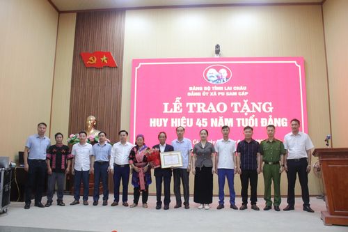 Lãnh đạo Đảng ủy, HĐND, UBND xã tặng hoa chúc mừng đồng chí Hầu A Lữ - đảng viên 45 năm tuổi Đảng.