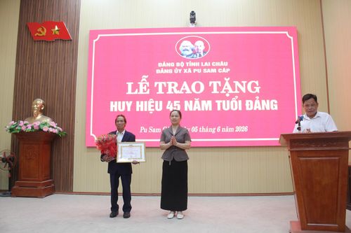 Đồng chí Nguyễn Thị Ngọc Hà - Bí thư Đảng ủy xã Pu Sam Cáp trao Huy hiệu 45 năm tuổi Đảng cho đồng chí Hầu A Lữ - Đảng viên Chi bộ bản Nà Phân.