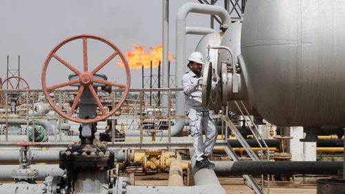  Một công nhân kiểm tra bể chứa tại mỏ dầu Nahr Bin Umar, phía bắc Basra, Iraq vào năm 2022. Ảnh: Reuters. 