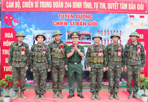 Đại tá Nguyễn Đình Khiêm, Phó chính ủy Bộ CHQS tỉnh Quảng Ninh tặng hoa bắn giỏi động viên chiến sĩ mới đạt kết quả cao tại nội dung bắn súng tiểu liên AK bài 1. 