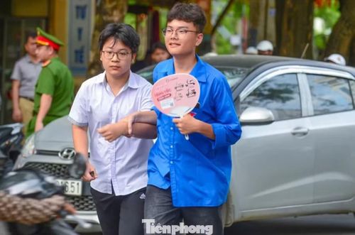 Tình nguyện viên dắt tay đưa sĩ tử qua đường, động viên trước giờ thi.