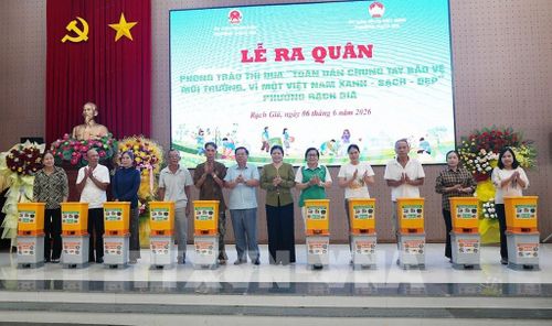 Trao tặng vật dụng chứa và phân loại rác thải cho hộ dân. Lê Huy Hải - TTXVN