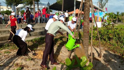 Các đại biểu tham gia trồng cây dọc bãi biển Nguyễn Tất Thành. Ảnh: ĐÌNH HIỀN
