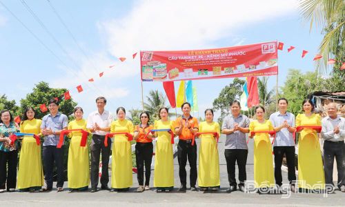 Lãnh đạo xã Mỹ Quí và đại biểu thực hiện nghi thức cắt băng khánh thành cầu Tabiket 36.