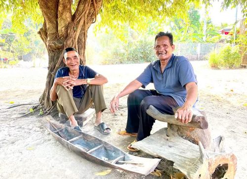 Già Pêng (bên trái) và già Hmơnh bên một chiếc thuyền độc mộc thu nhỏ. Ảnh: P.D