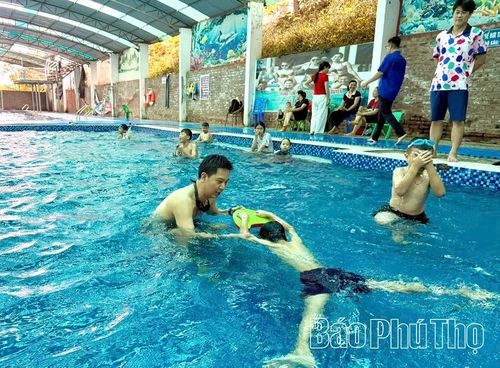 Huấn luyện viên hướng dẫn kỹ các em kỹ thuật bơi ếch.