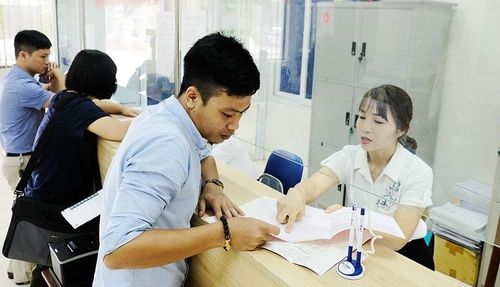 Cán bộ hướng dẫn người dân làm thủ tục hành chính tại UBND xã Sóc Sơn. Ảnh: Phạm Hùng