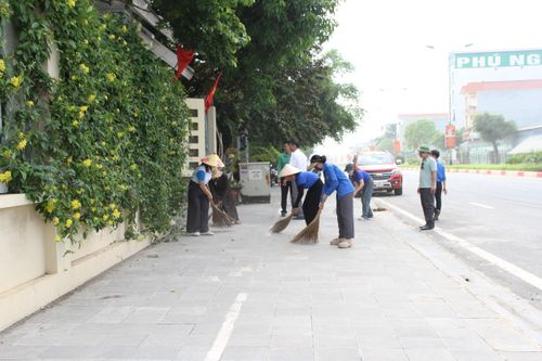 Các lực lượng thu gom rác thải, vệ sinh môi trường tại vỉa hè tuyến đường 424, thôn 10. Ảnh: Biên Phạm