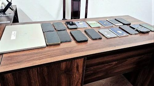 Lực lượng chức năng thu giữ tang vật gồm: 30 chiếc điện thoại di động, 2 máy tính xách tay, 15 hộ chiếu, 1 xe ô-tô cùng nhiều tang vật khác liên quan. Quá trình khám xét chỗ ở đối tượng liên quan, lực lượng chức năng còn thu giữ thêm 20,48 gram ma túy các loại. (Ảnh: Công an Nghệ An)