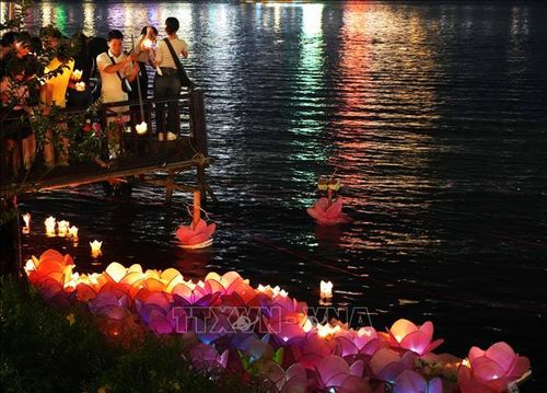 Tăng ni, phật tử tham gia Lễ hội hoa đăng tiến hành thả hoa đăng xuống sông Hương, thành phố Huế.