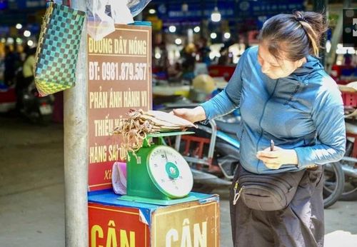 Du khách kiểm tra lại trọng lượng hải sản tại điểm cân đối chứng ở chợ Cột Đỏ.