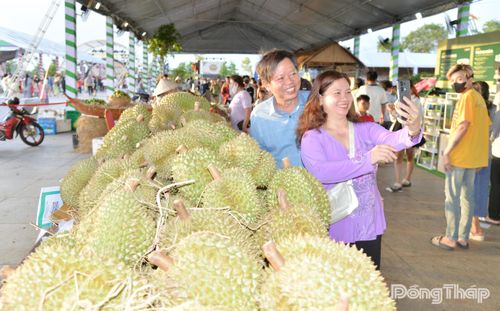 Người dân phấn khởi chụp ảnh bên khu vực trưng bày trái cây đặc sản của Đồng Tháp.