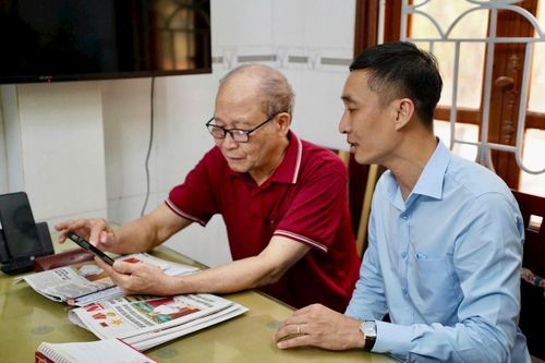 Cán bộ Xí nghiệp Kinh doanh nước sạch Ba Đình hướng dẫn người dân số hóa thủ tục hành chính. Ảnh: Thu Thủy.