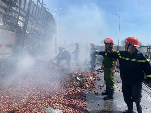 Hiện trường vụ cháy xe, hàng hóa đổ xuống đường. Ảnh: Tiền Phong.