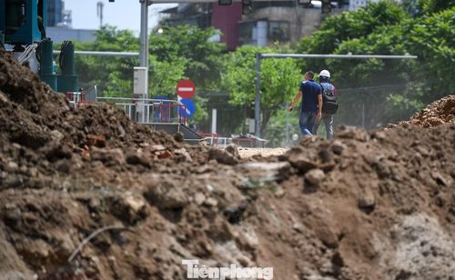 Từ sáng sớm, công nhân đã có mặt tại các mũi thi công để tháo dỡ công trình, vận chuyển vật liệu, gia cố nền đường và xử lý hạ tầng kỹ thuật. Đến giữa trưa, nền nhiệt ngoài trời liên tục tăng cao, nhiều khu vực bê tông và mặt đường nóng rát dưới nắng hè.