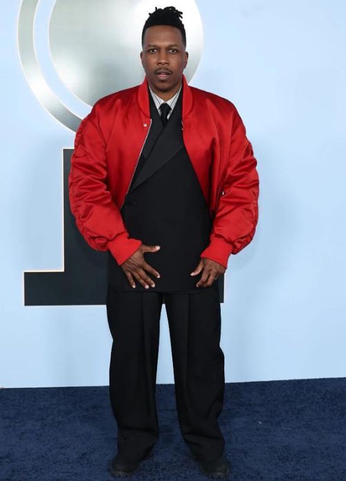 Ngôi sao của Hamilton, Leslie Odom Jr., xuất hiện với bộ suit đen bất đối xứng, kết hợp áo khoác bomber đỏ bên ngoài để tạo điểm nhấn nổi bật. Ảnh: Getty