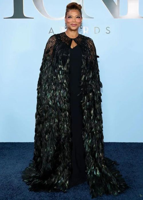 Queen Latifah, người sẽ tham gia trao giải tại lễ trao giải năm nay, xuất hiện trên thảm đỏ với bộ trang phục đen lấp lánh. Chiếc đầm dài chạm đất được kết hợp cùng áo choàng phủ lông vũ, tạo hiệu ứng đổi màu từ xanh dương sang đen rồi xanh lá khi bắt sáng. Ảnh: Getty