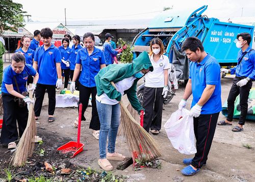 Đoàn viên, thanh niên xã Vĩnh Điều thu gom rác thải tại khuôn viên chợ Tà Êm. Ảnh: THANH NHÃ