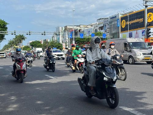 Người dân kín mít áo chống nắng ra đường. Ảnh: KHÁNH NGÂN