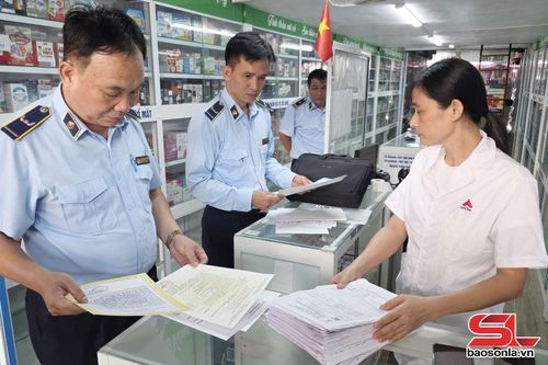 Cán bộ Đội QLTT số 6 kiểm tra nhãn hiệu các mặt hàng dược phẩm trên địa bàn xã Sông Mã.
