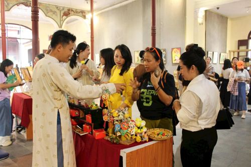 Nghệ nhân Đặng Văn Hậu giới thiệu với du khách về sản phẩm tò he Xuân La. Ảnh: Vi Giáng
