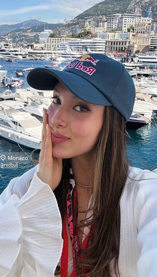 Lily Muni, bạn gái của Alex Albon, cũng gây chú ý khi xuất hiện tại trường đua với phong cách năng động. Cô chọn áo khoác trắng dáng rộng, tay bồng, phối cùng áo ren bên trong, tạo tổng thể nhẹ nhàng và hài hòa, kết hợp vòng cổ bạc mảnh và mũ lưỡi trai Red Bull màu xanh đậm. Sinh ra tại Trung Quốc, Lily hiện là golfer thi đấu tại LPGA. Cô từng học truyền thông tại Đại học Nam California trước khi chuyển sang thi đấu chuyên nghiệp năm 2017. Ảnh: @lilymhe/IG.
