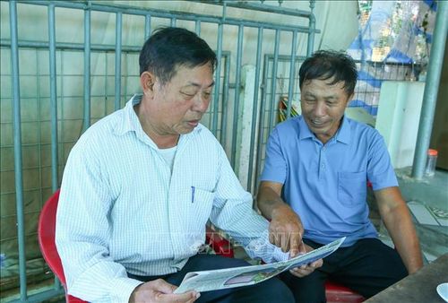 Cựu chiến binh Đỗ Đình Giao (phải) thường xuyên đọc báo để cập nhật thông tin.