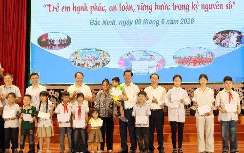  Đồng chí Lê Xuân Lợi (thứ 5 từ trái qua) và các đại biểu tặng quà các cháu thiếu nhi có hoàn cảnh khó khăn trên địa bàn xã Lạng Giang. 