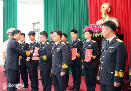 Đại tá Nguyễn Hữu Lương trao quyết định thăng quân hàm cho các cán bộ. Ảnh: ĐVCC