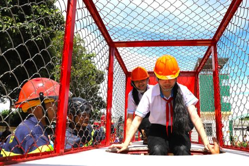 Các em học sinh hào hứng trải nghiệm khu vực di chuyển thoát nạn trong không gian hạn chế