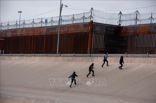 Người di cư chuẩn bị vượt qua bức tường biên giới Mỹ - Mexico, tại Ciudad Juarez, Mexico. Ảnh: THX/TTXVN