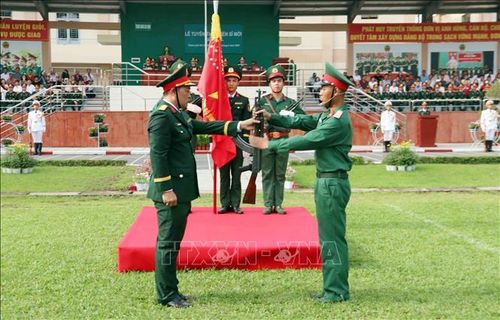 Trung tá Phạm Đình Cường (trái), Trung đoàn trưởng Trung đoàn Gia Định thực hiện nghi thức trao vũ khí cho chiến sĩ mới.