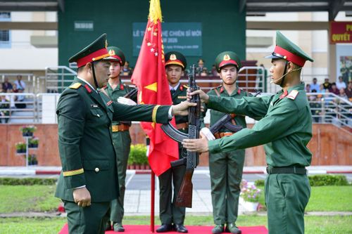 Trung đoàn trưởng Trung đoàn Gia Định thực hiện nghi thức trao vũ khí cho chiến sĩ mới.
