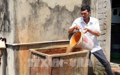 Hàng trăm hộ dân xã Tân Gianh (Quảng Trị) phải sử dụng nước giếng khoan bị nhiễm phèn rồi lọc qua cát mới có nước sinh hoạt vào mùa nắng nóng. Ảnh: Tá Chuyên - TTXVN