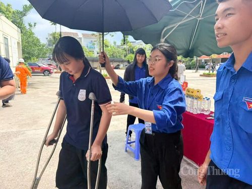 Thí sinh bị đau chân được sinh viên tình nguyện hỗ trợ tận tình.
