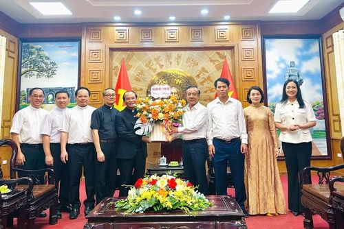 Giám mục Nguyễn Đức Cường tặng hoa chúc mừng đồng chí Lê Đức Thái, Ủy viên Trung ương Đảng, Bí thư Tỉnh ủy, Trưởng Đoàn đại biểu Quốc hội tỉnh