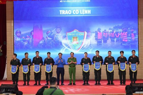 Đại tá Nguyễn Văn Trầm và đồng chí Nguyễn Đức Nguyên, Phó Trưởng ban Công tác thanh thiếu nhi Trung ương Đoàn, Phó Chủ tịch Trung ương Hội Sinh viên Việt Nam trao Trao cờ lệnh xuất quân.
