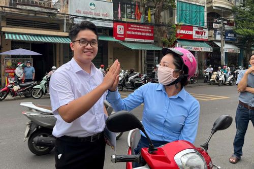 Phụ huynh tiếp thêm tinh thần cho con em mình trước khi vào phòng thi. Ảnh: CĐ.