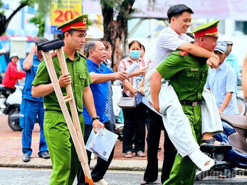 Cán bộ Công an Cà Mau trực tiếp hỗ trợ em Lê Đăng Khoa đến phòng thi tại Trường trung học phổ thông Hồ Thị Kỷ an toàn.