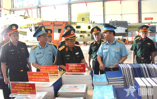 Đại tá Phạm Bá Nguyên, Giám đốc Nhà máy A32 giới thiệu với Trung tướng Trần Minh Đức, Chủ nhiệm Tổng cục Hậu cần-Kỹ thuật về tài liệu quy trình công nghệ sửa chữa máy bay Su-27, Su-30 của Nhà máy. Ảnh: HỒ KHÁNH