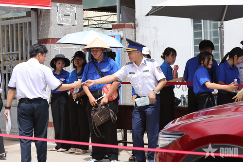 Cán bộ, chiến sĩ Hải đội 401 trao nước uống và bút viết tặng học sinh lớp 12 Trường THPT An Thới. 