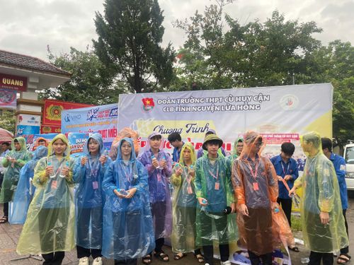  Đoàn viên, thanh niên dùng mang áo mưa cầm chai nước để trao cho các thí sinh 