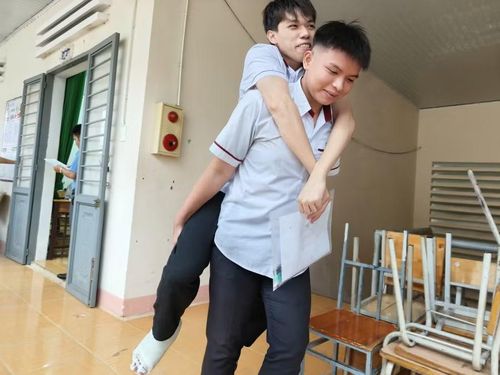Sau 8 ngày bị gãy chân, thí sinh Hữu Tuấn Anh vẫn nén đau để dự thi "nhờ" đôi chân của bạn học cùng lớp. (Ảnh: Thế Hùng)